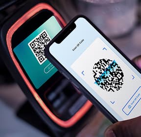 A phone is held with its back panel against a payment terminal