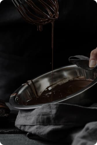 Chocolate is dripping from the whisk into the bowl